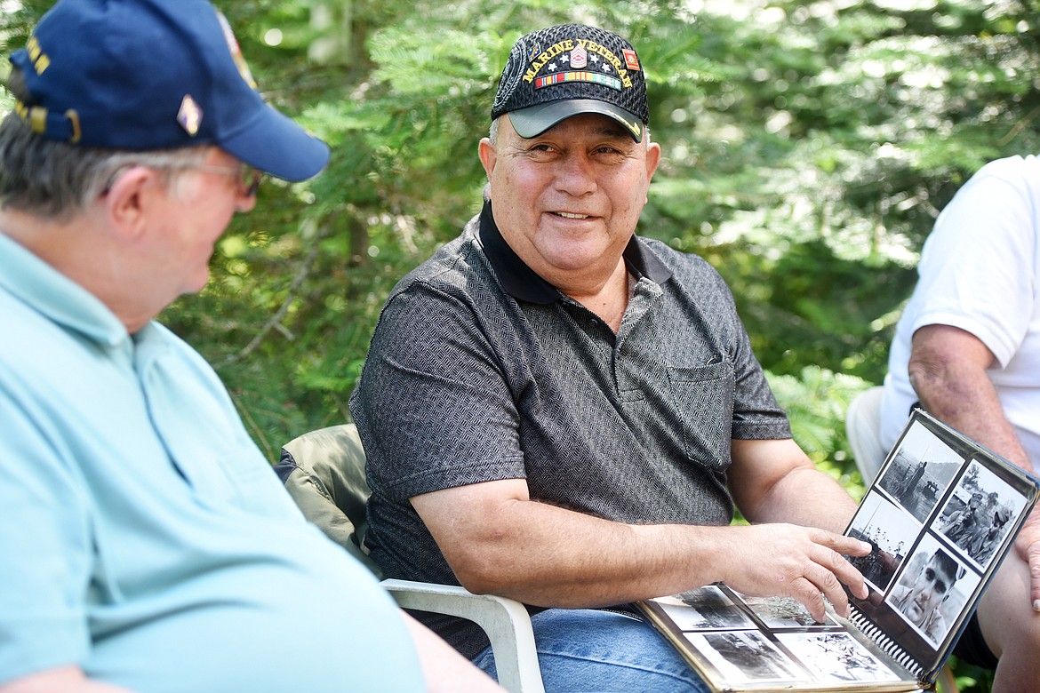 Fred Sotello, the only Marine at the reunion who stayed in for 20 years and retired as a Master Sergeant, shares memories while looking through a photo album at their reunion on Sunday, June 24, in Columbia Falls.(Brenda Ahearn/Daily Inter Lake)