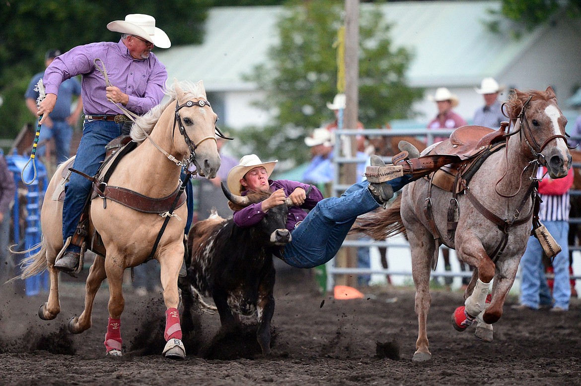 Kris Anderson, center, of Hamilton, competes during the Steer Wrestling event at the Bigfork Summer Pro Rodeo on Friday. (Casey Kreider/Daily Inter Lake)