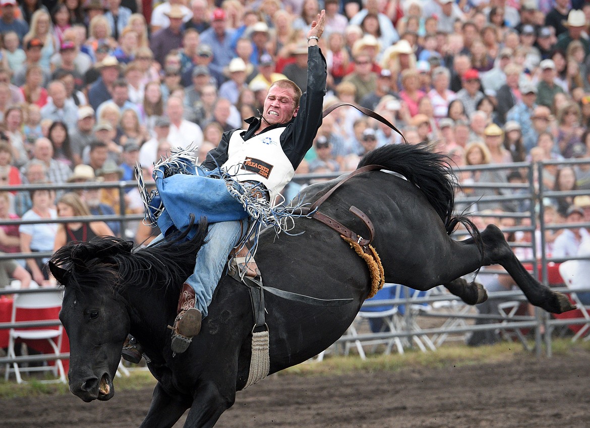 Pascal Isabelle, of Okotoks, Alberta, Canada, hangs on to his horse Midnight Dolly during the Bareback Riding event at the Bigfork Summer Pro Rodeo on Friday. (Casey Kreider/Daily Inter Lake)