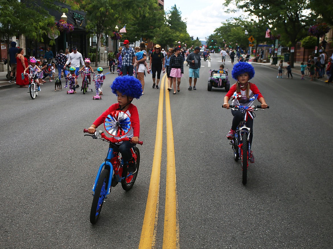 Bud Miller, 6, left, and his sister, Cora, 8, ride their bikes down Sherman Avenue during Coeur d'Alene's Kids Parade on Tuesday. (LOREN BENOIT/Press)