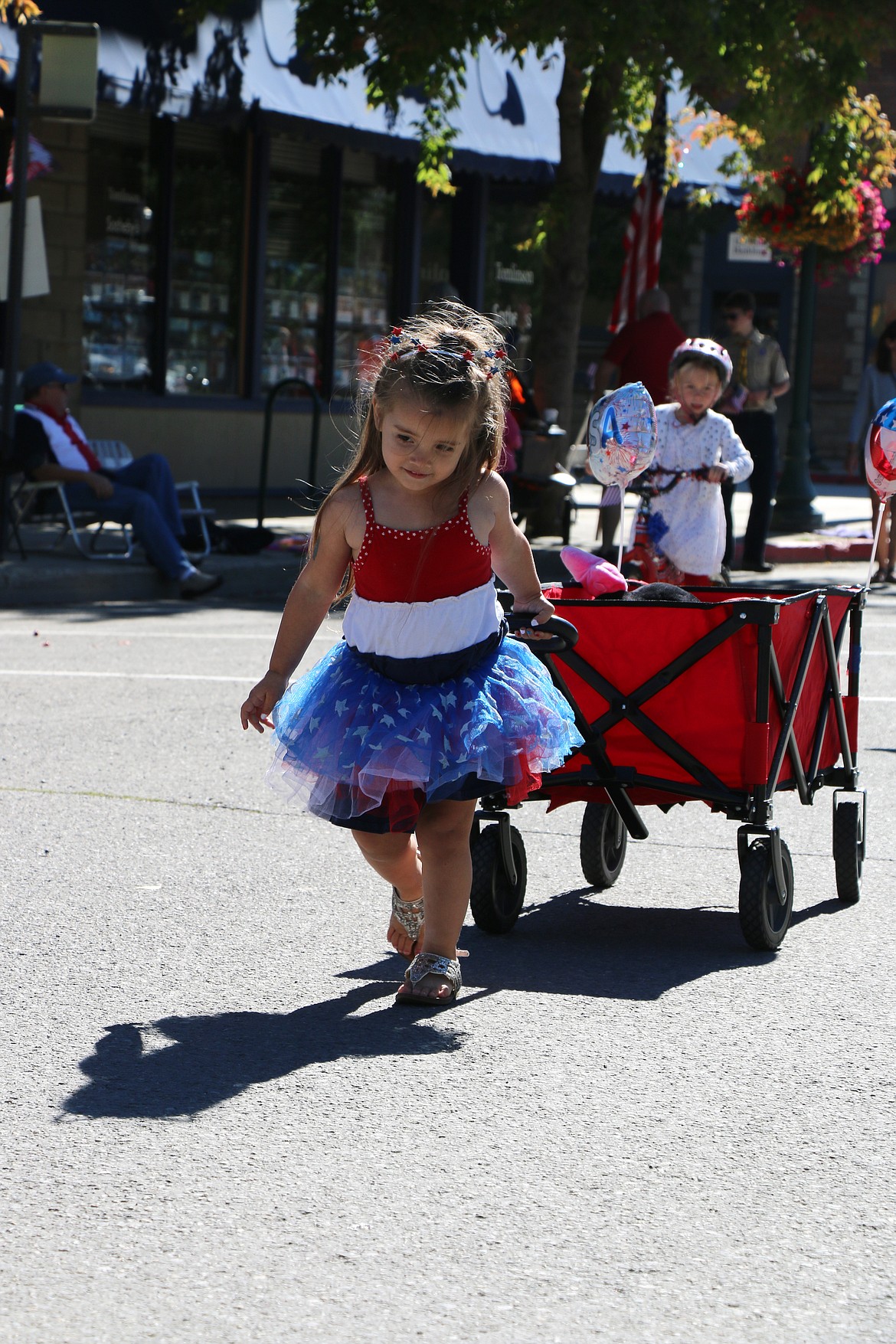 (Photo by CAROLINE LOBSINGER)A youngster pulls a wagon during the Sandpoint Lions' Kids Parade on the Fourth of July Wednesday.