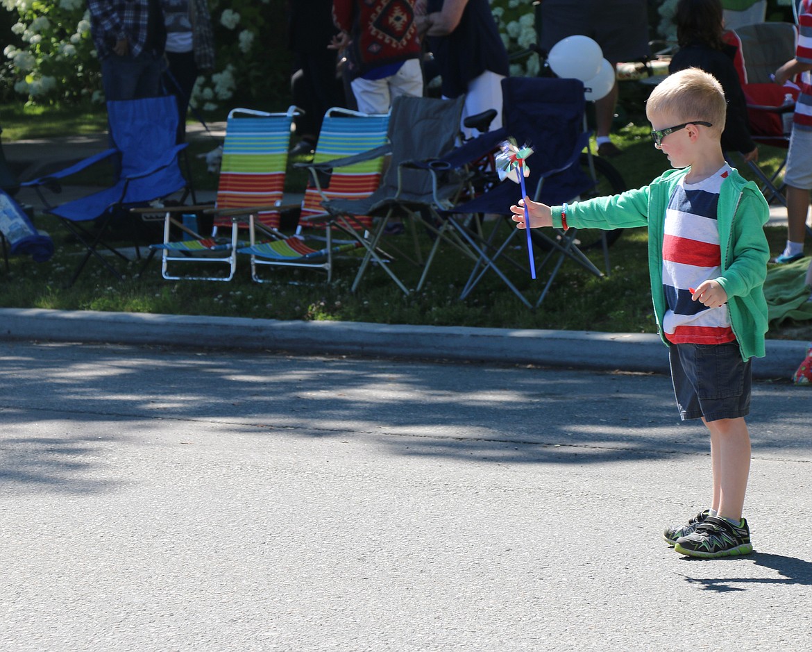 (Photo by CAROLINE LOBSINGER)A youngster tries out his pinwheel as he waits for the start of the Sandpoint Lions' Grand Parade on the Fourth of July on Wednesday.