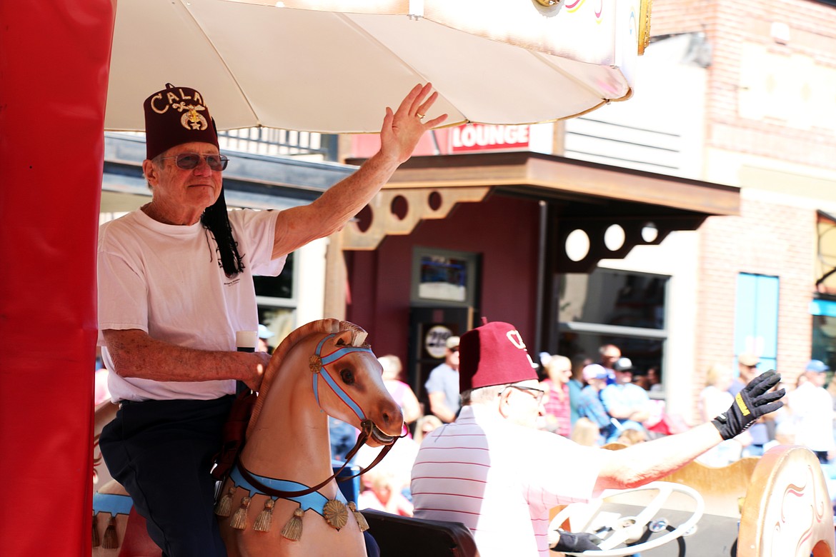 (Photo by CAROLINE LOBSINGER)Area Shriners wave to the crowd as they take part in the Sandpoint Lions' Grand Parade on the Fourth of July on Wednesday.