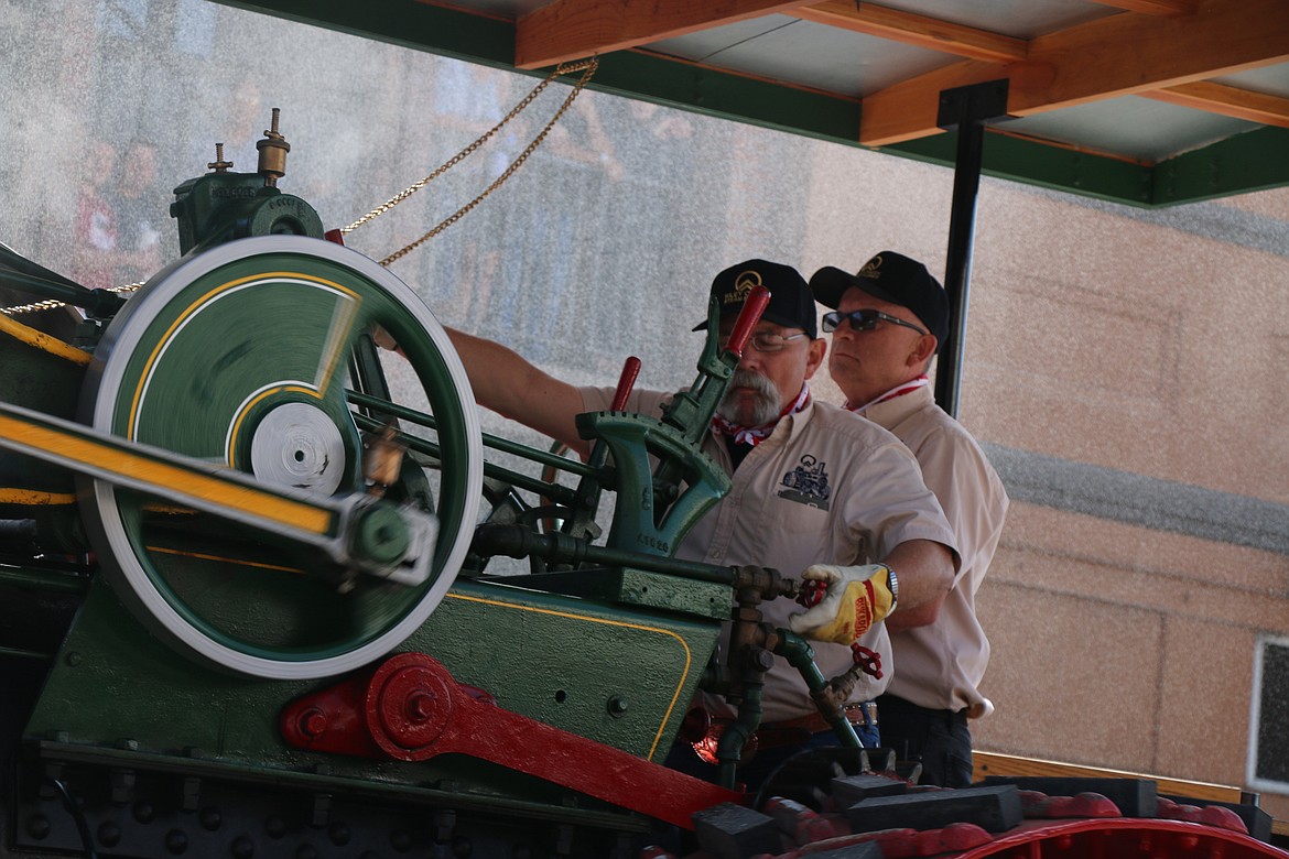 (Photo by CAROLINE LOBSINGER)Panhandle Antique Tractor and Engine Club members drive an antique machine down First Avenue during the Sandpoint Lions' Grand Parade on the Fourth of July on Wednesday.