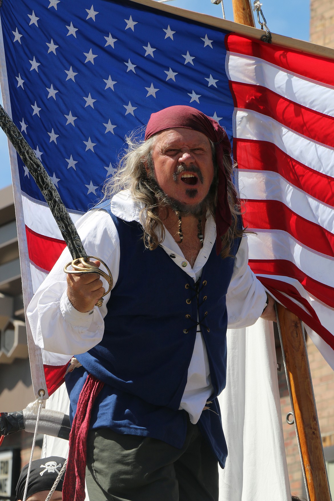 (Photo by CAROLINE LOBSINGER)&quot;Captain Dan&quot; Mimmack does his best pirate imitation as he rides on the Creations float during the Sandpoint Lions' Grand Parade on the Fourth of July on Wednesday.