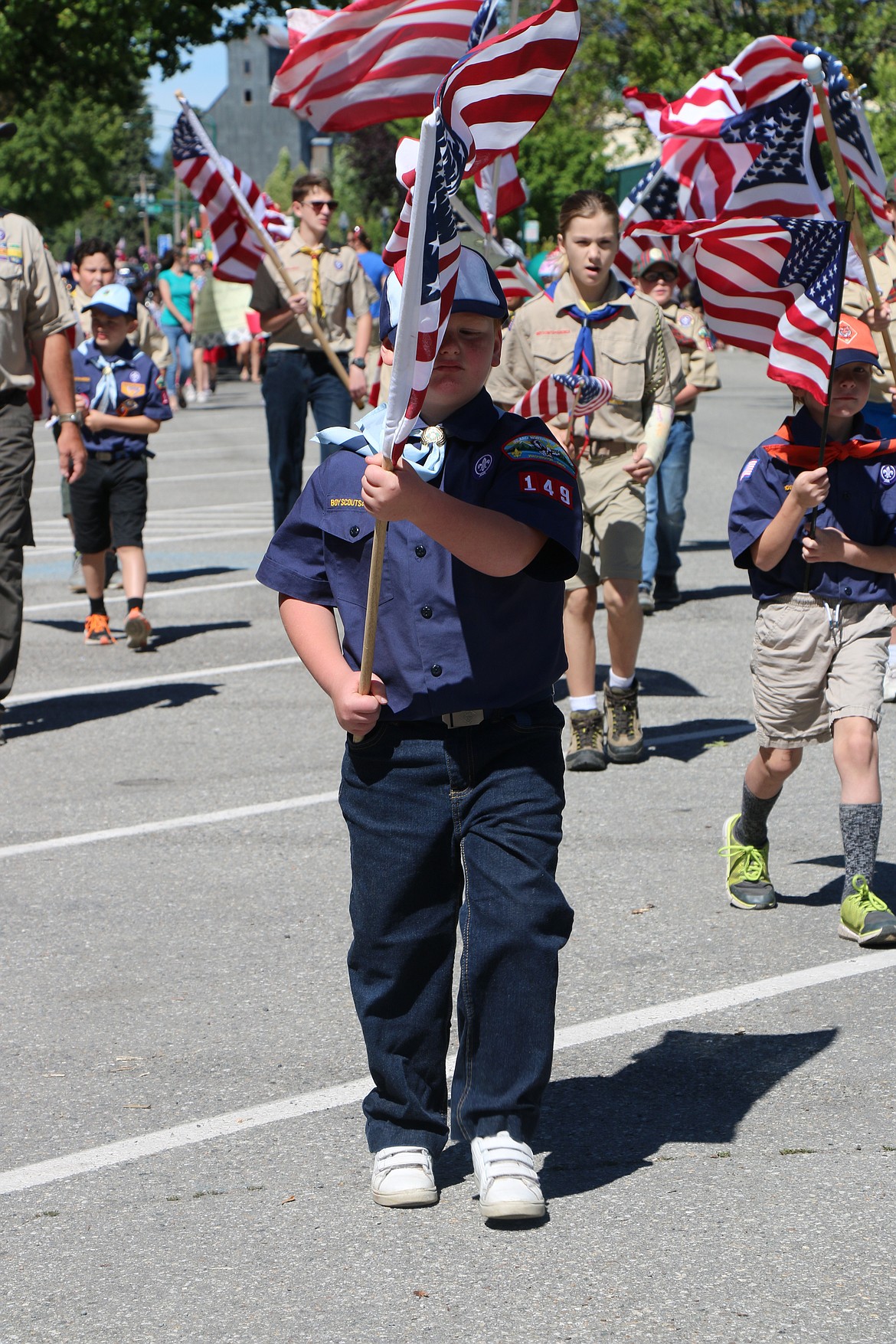 (Photo by CAROLINE LOBSINGER)A young scout carries the American flag down Church Street during the Sandpoint Lions' Grand Parade on the Fourth of July on Wednesday.