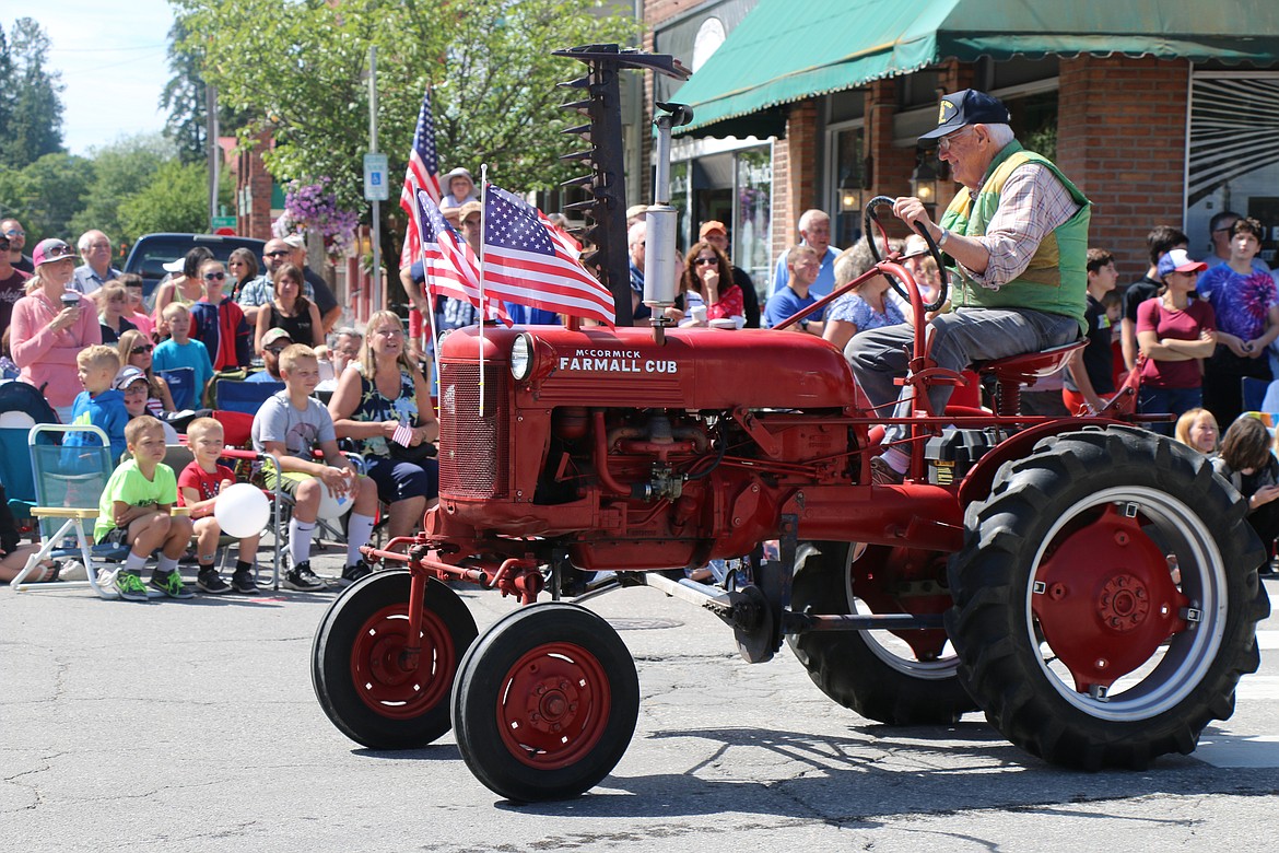 (Photo by CAROLINE LOBSINGER)A member of the Panhandle Antique Tractor and Engine Club takes part in the Sandpoint Lions' Grand Parade on the Fourth of July Wednesday.