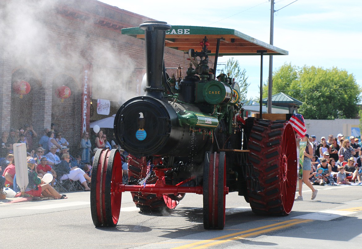 (Photo by CAROLINE LOBSINGER)A Panhandle Antique Tractor and Engine Club member takes part in the Sandpoint Lions' Grand Parade on the Fourth of July on Wednesday.