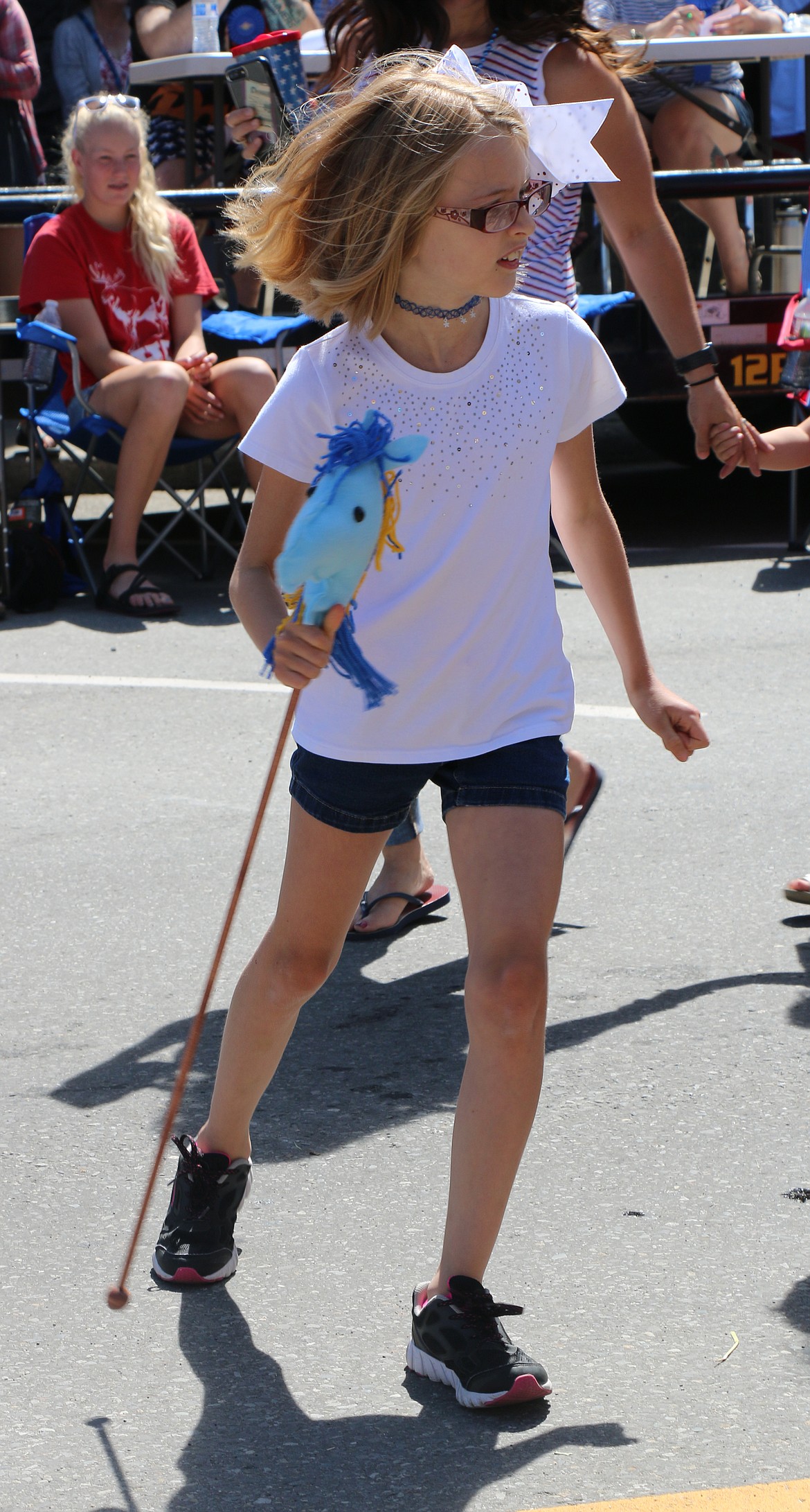 (Photo by CAROLINE LOBSINGER)A youngster takes to the streets as she joins the Carousel of Smiles parade entry during the Sandpoint Lions' Grand Parade on the Fourth of July Wednesday.