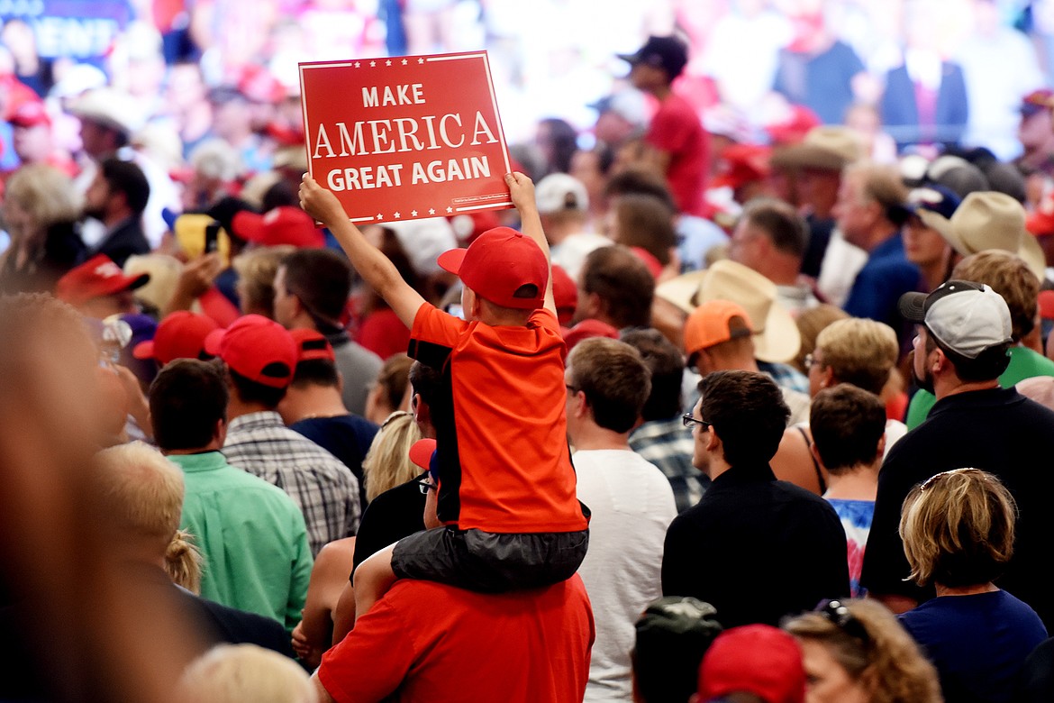 A small boy sits on his father&#146;s shoulders holding a &#147;Make America Great Again&#148; sign as they listen to President Donald J. Trump on Thursday, July 5, in Great Falls.(Brenda Ahearn/Daily Inter Lake)