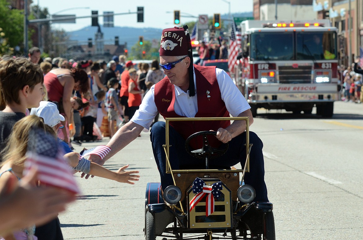 The Shriners cruise Main Street in mini cars.