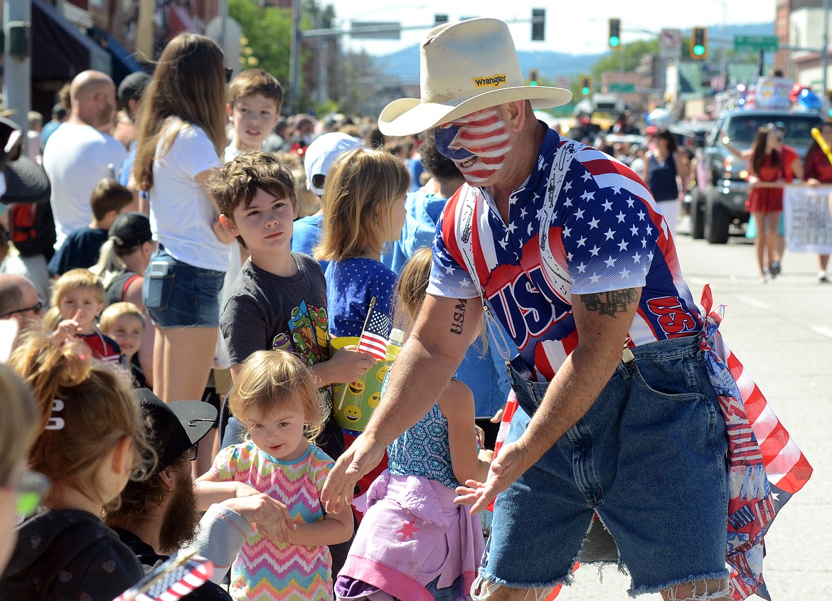 Paradegoers are decked out in red, while and blue.