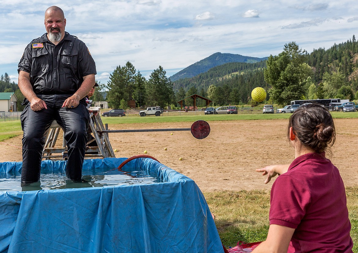 Ashley Masterson of Troy, right, attempts unsuccessfully to dunk Troy Police Officer Travis Miller at Roosevelt Park in Troy July 4. (John Blodgett/The Western News)