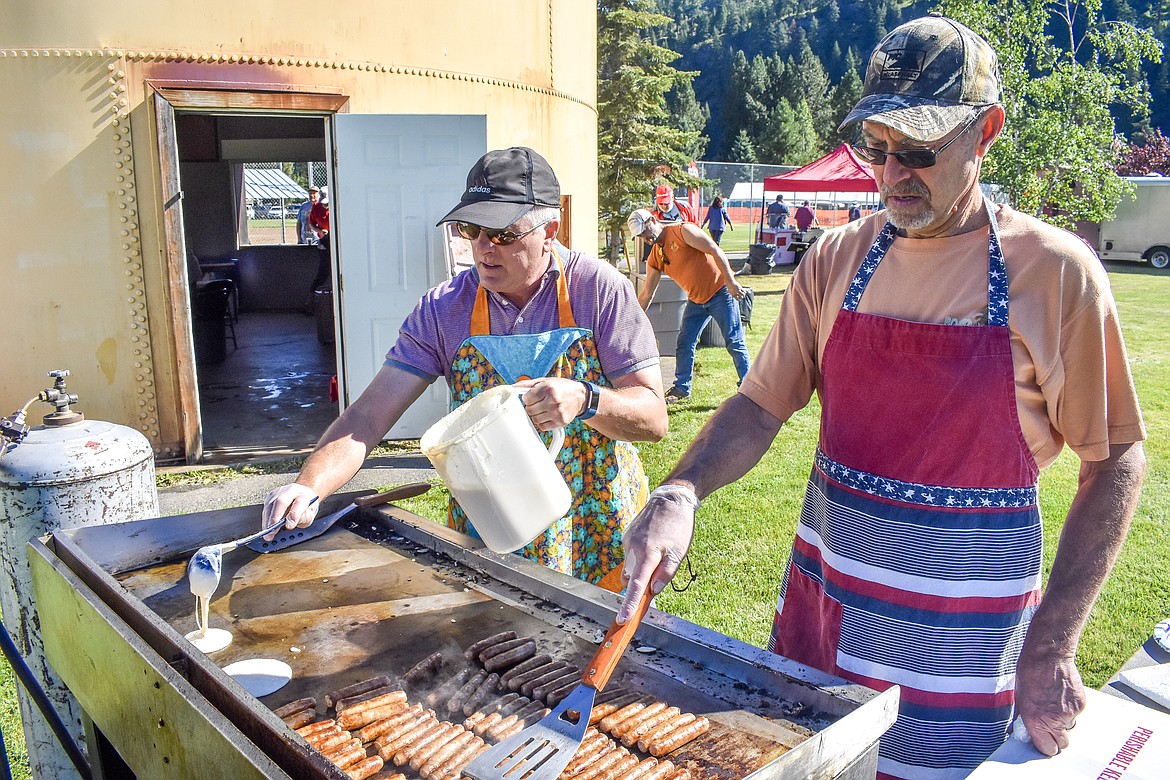 Roy Richardson and Rick Blomdahl fix sausage and pancakes at Roosevelt Park July 4. The two neighbors said that they and others from their neighborhood have been helping to prepare the traditional breakfast at the park each year for about a decade and a half. (Ben Kibbey/The Western News)