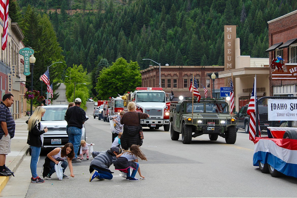 Photo by CHANSE WATSON/ 
Happy children scurry out to grab candy as the Wallace Statehood Day Parade rolls down Bank St. on July 3.