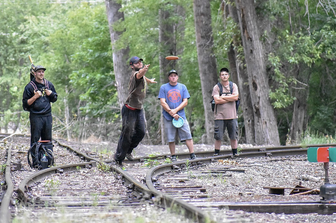 Where the course crosses defunct railroad tracks, Tyler Suiter from Spokane shoots for the 14th hole during the Timber Beast Disc Golf Tournament on Saturday, June 30. (Ben Kibbey/The Western News)