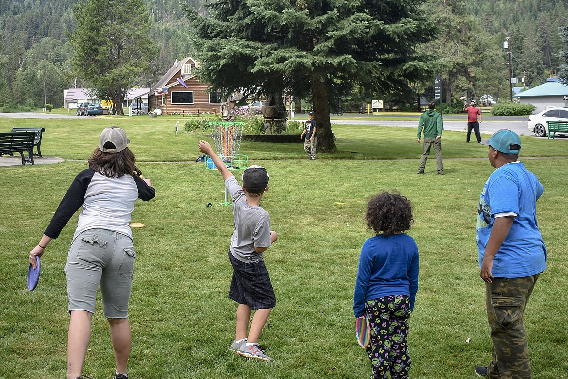 A group of junior and adult players gathered round the a practice basket on the Troy Museum lawn while awaiting their shot at the course during the Timber Beast Disc Golf Tournament on Saturday, June 30. (Ben Kibbey/The Western News)