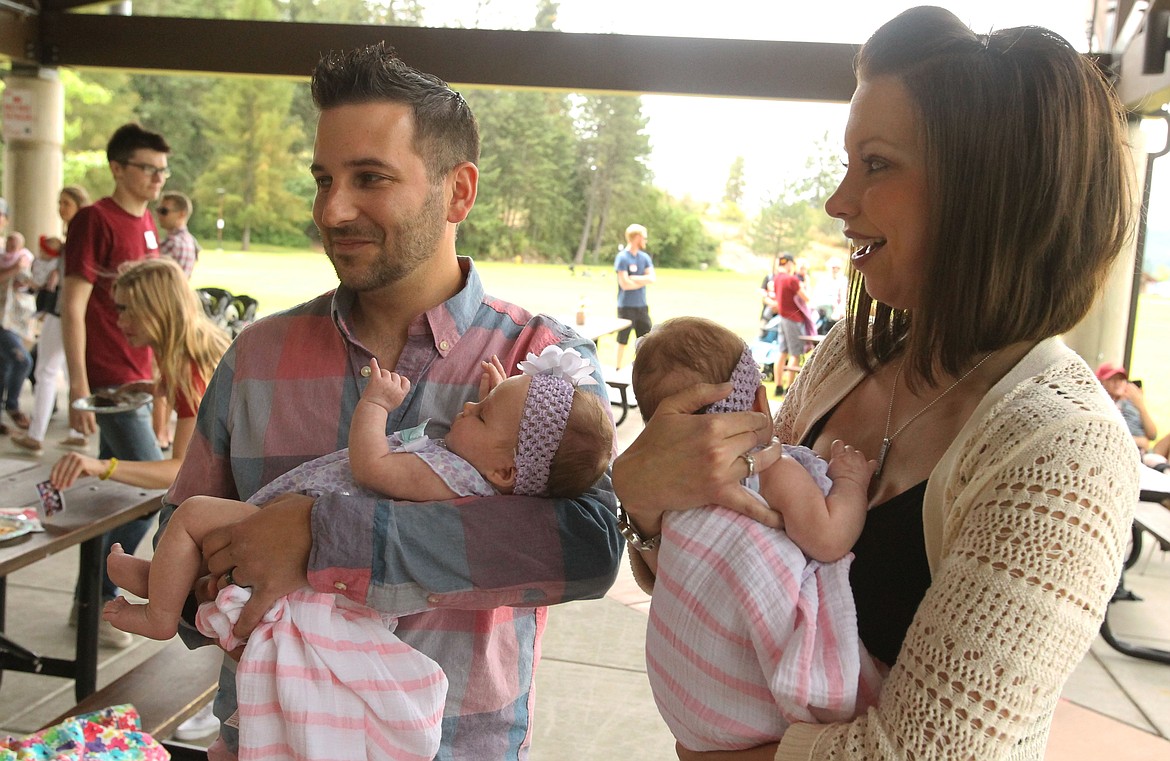 Proud Coeur d&#146;Alene parents Michael Emerson, holding daughter Aria, and Calaise Emerson, holding daughter Adalyn, visit with friends and medical staff Saturday during the Kootenai Health Neonatal Intensive Care Unit reunion in the McEuen Park picnic pavilion.
