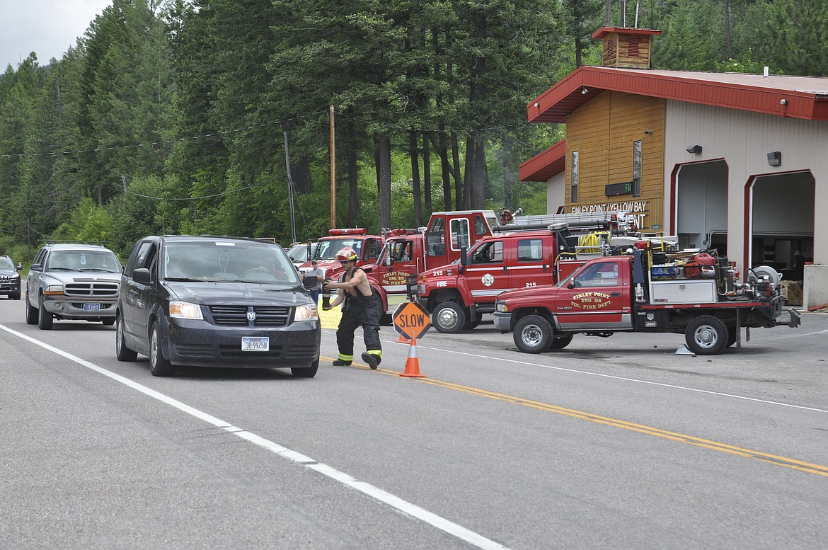 ERIC ANDERSON accepts a donation by a motorist Saturday, June 30, during an open house fundraiser at the Finley Point/Yellow Bay fire station on Montana Highway 35. (Ashley Fox/Lake County Leader)