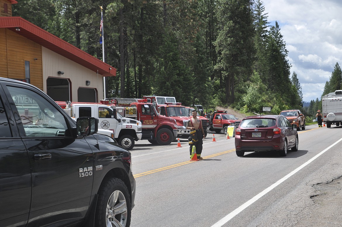 VOLUNTEER FIREFIGHTER Rhett Burland smiles as he welcomes a truck through the Finley Point area in front of the area&#146;s fire department Saturday, June 30. (Ashley Fox/Lake County Leader