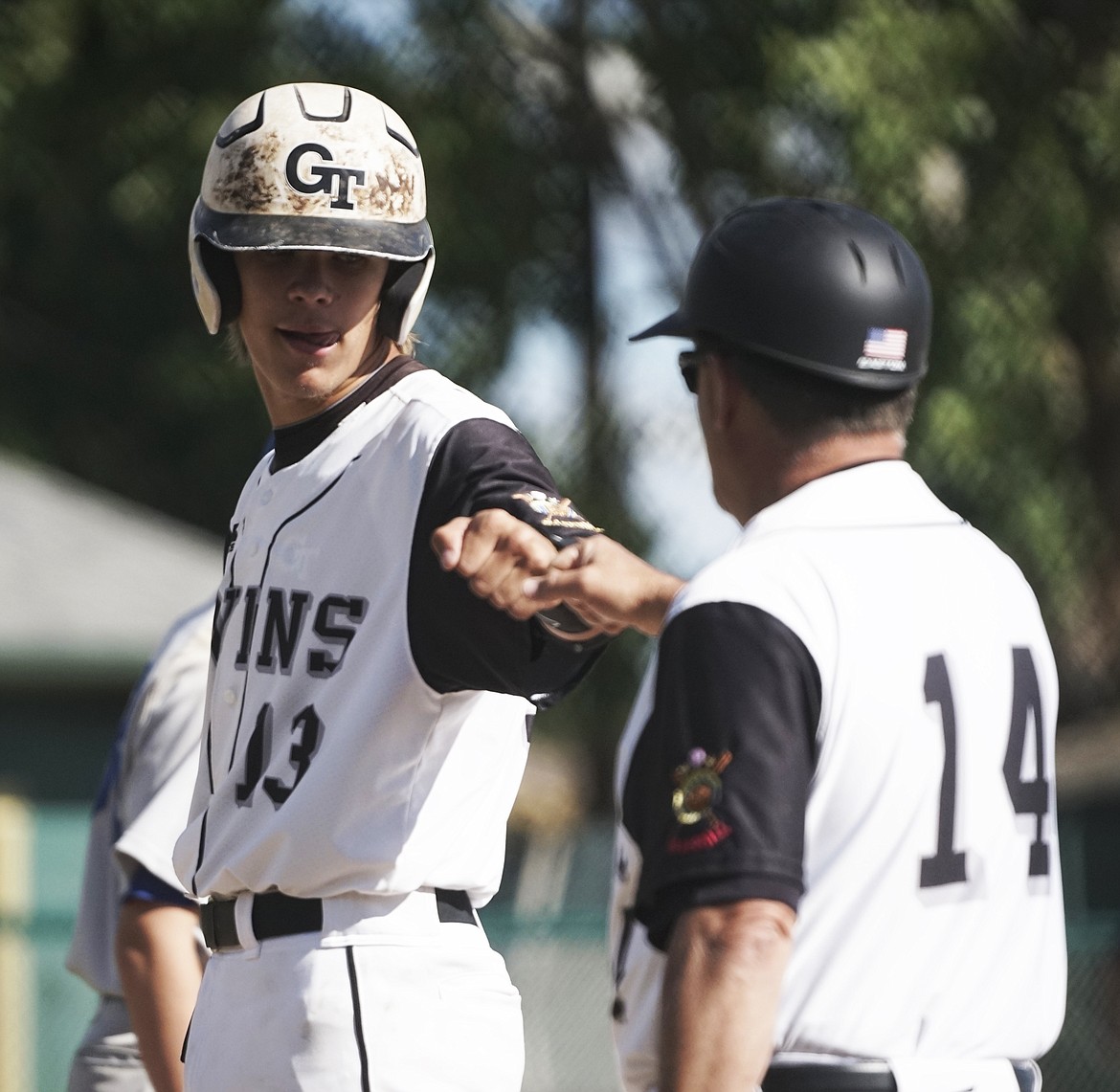 Ryan Veneman fist bumps coach Scott Murray after a base hit during Tuesday's clobbering of Libby at Memorial Field.