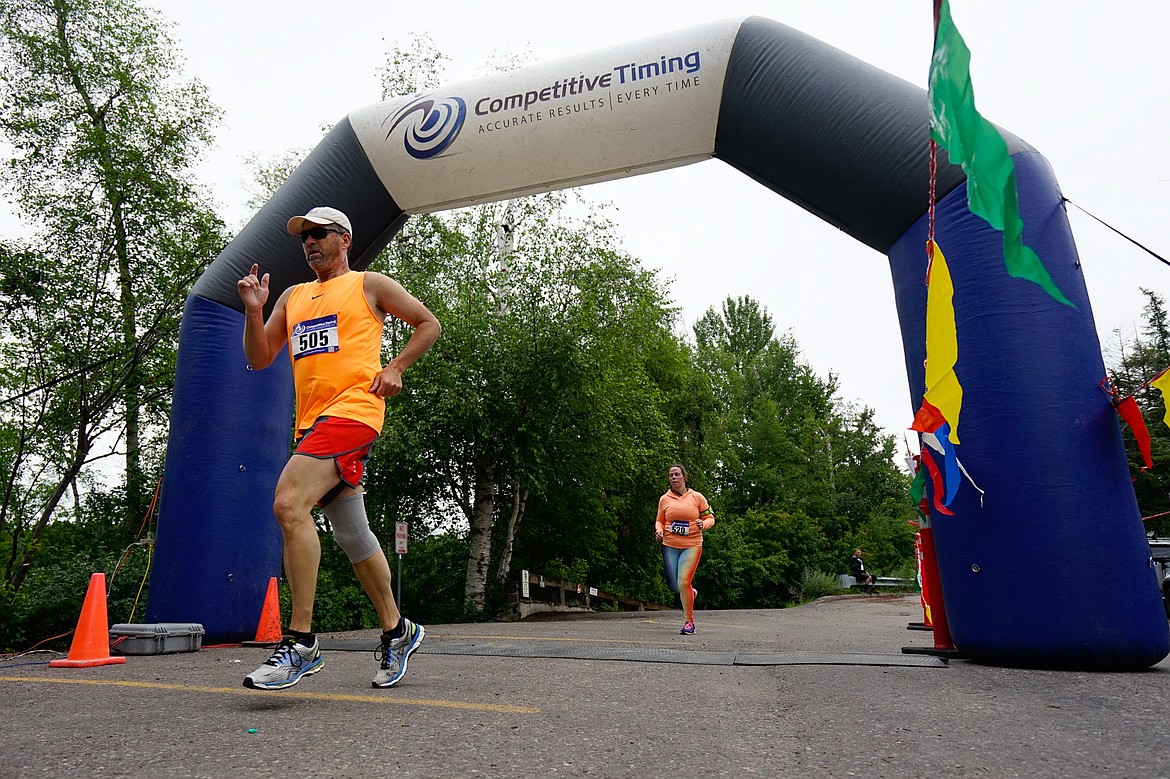 Runners cross the finish line at City Beach during the Glacier Challenge on Saturday.