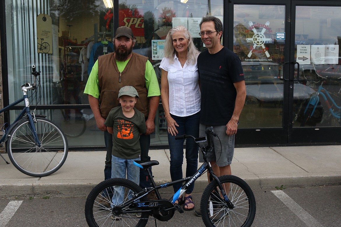 Local 7-year-old Easton McNall, front, poses with his new bike. Also pictured are Sandpoint Sports owners Lisa Campbell, center, and Svein Nostdahl, right. 
(Photo by MARY MALONE)