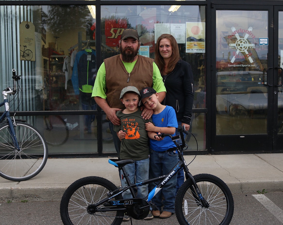 (Photo by MARY MALONE)Local 7-year-old Easton McNall, front left, poses with his new bike, as he was the first recipient of a bike donated through a new program by Sandpoint Sports owners Lisa Campbell and Svein Nostdahl (not pictured). Campbell is making earrings out of bicycle tire tubes and selling them to purchase a new bikes for deserving children in the community. Also pictured is Easton&#146;s brother Holt McNall, front right, his father Dan McNall, top left, and mother Amanda McNall, top right.