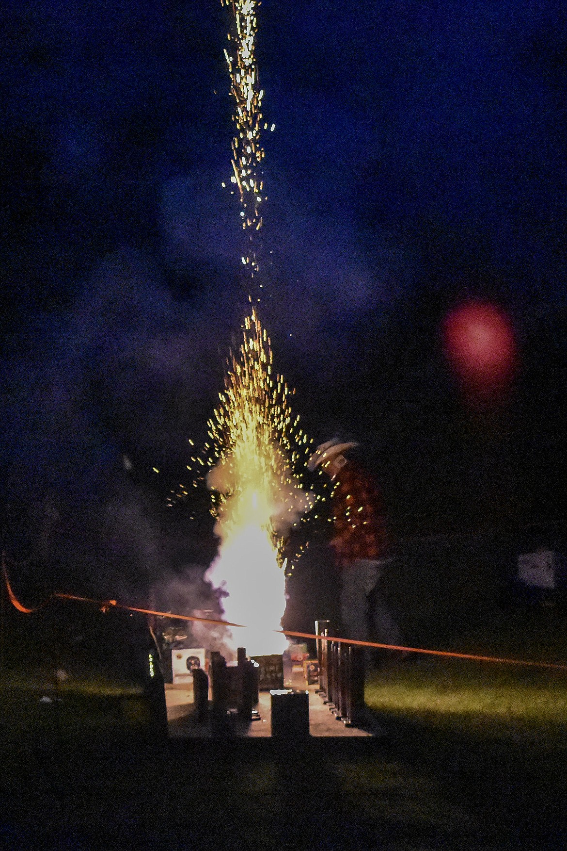 One of the set of fireworks blows off as Joe Wade walks the line to light the next fuse, during the annual Fourth of July fireworks display on Saturday, June 30. (Ben Kibbey/The Western News)
