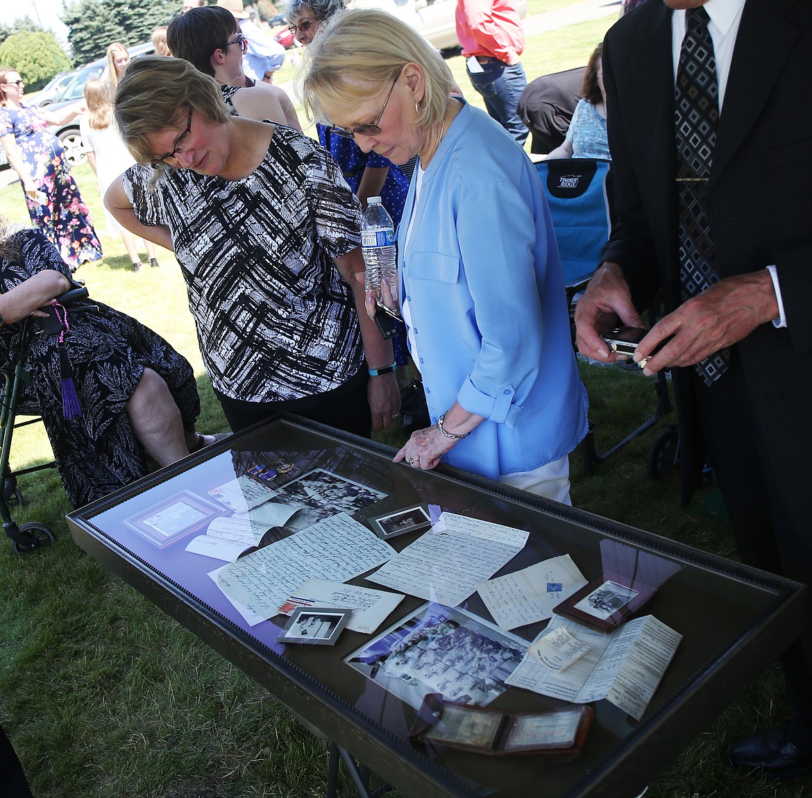 Linda Georgeson, left, and Linda Vercoe view old letters, photos and other momentos Tuesday at Charles Daman's Ceremony at Coeur d'Alene Memorial Gardens. (LOREN BENOIT/Press)