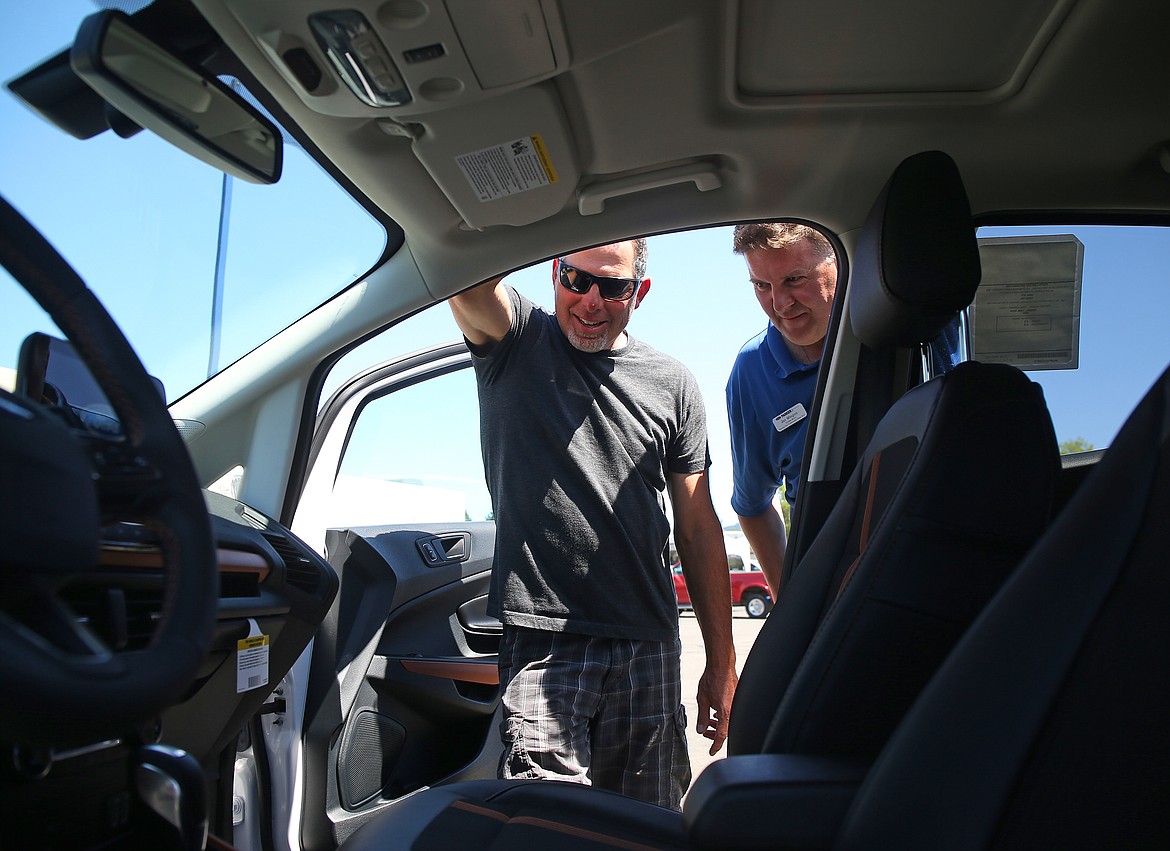 Salesman Jan Wingren, right, and customer Matt Melton look at the inside of a Ford Ecosport SES Monday afternoon at Mike White Ford in Coeur d&#146;Alene.