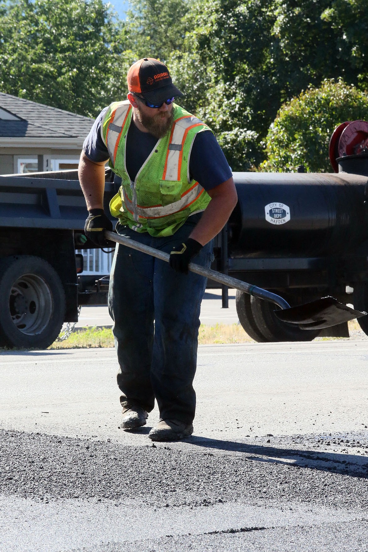 Tyler Newton, crewman operator for the city of Hayden, makes a paving project on Government Way look straight and clean on Wednesday. (JUDD WILSON/Press)