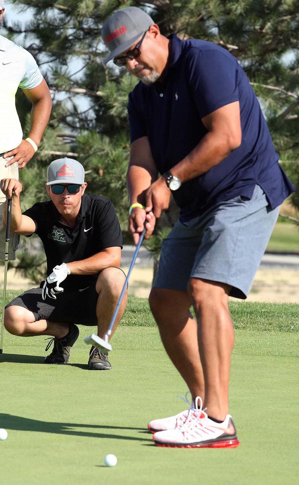 Rodney Harwood/Columbia Basin HeraldTeam Zamora has been active in the Moses Lake wrestling golf scramble. Joey putts as Pete checks out the read during the 2017 tournament