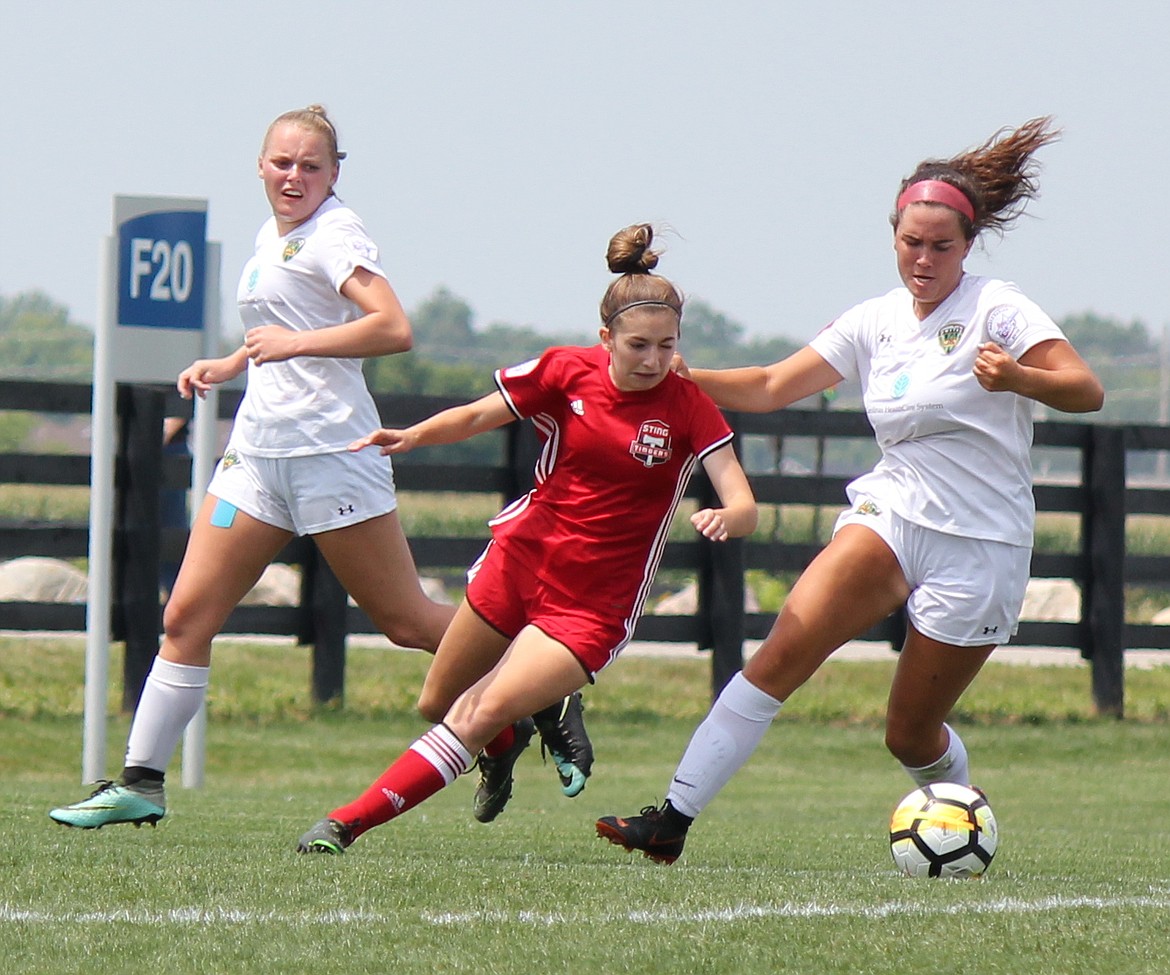 Photo courtesy LEE RIEKEN
Madyson Smith of the Sting Timbers 00/01 girls soccer team manuevers between a pair of players from CUFC Gold of North Carolina in Thursday&#146;s game at the US Youth Soccer National Presidents Cup in Westfield, Ind.