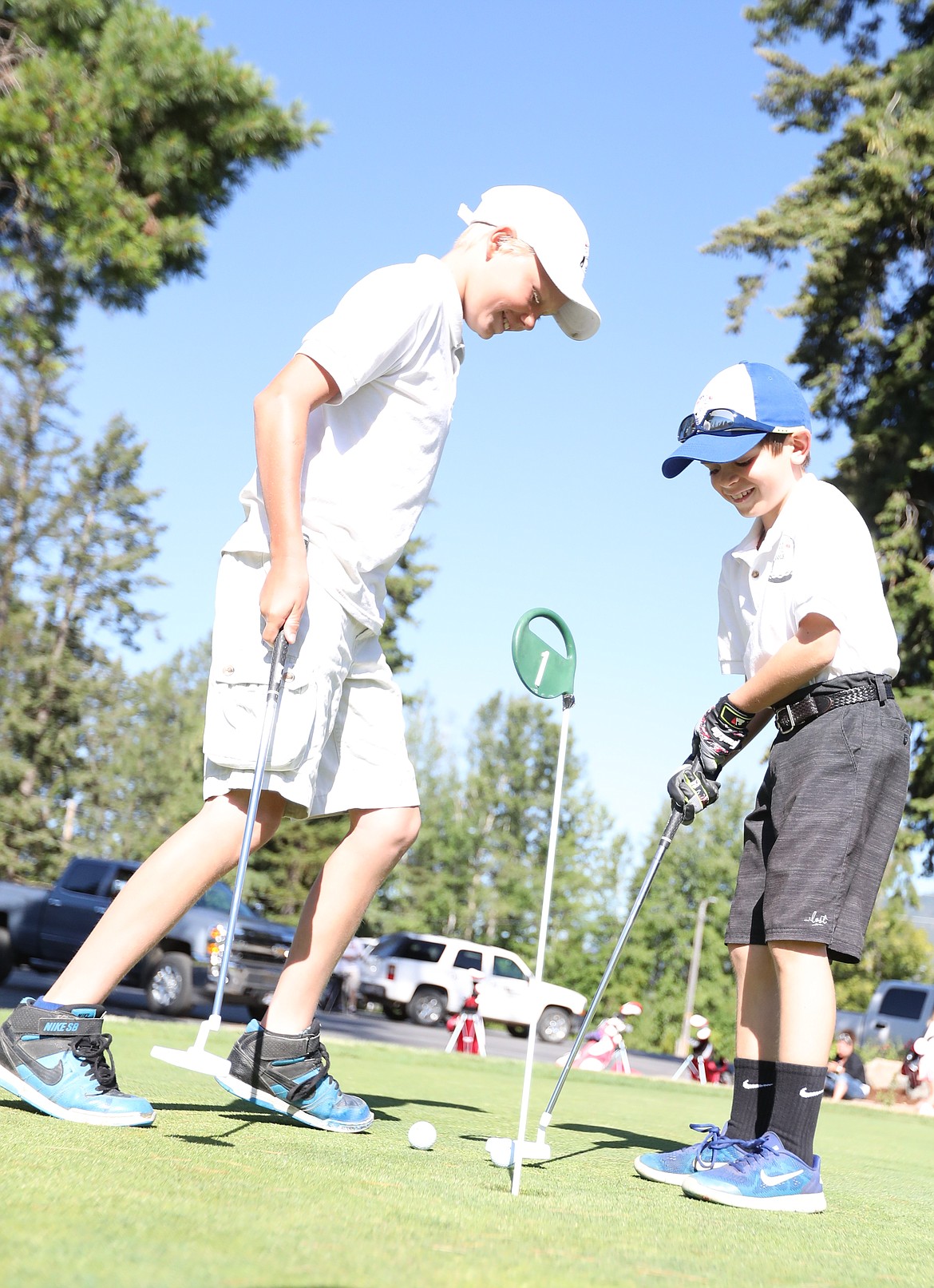 (Photo by ERIC PLUMMER)
Avery Beard, left, and Kurt Schimkowitsch have fun putting on the practice green on Friday at the Elks.