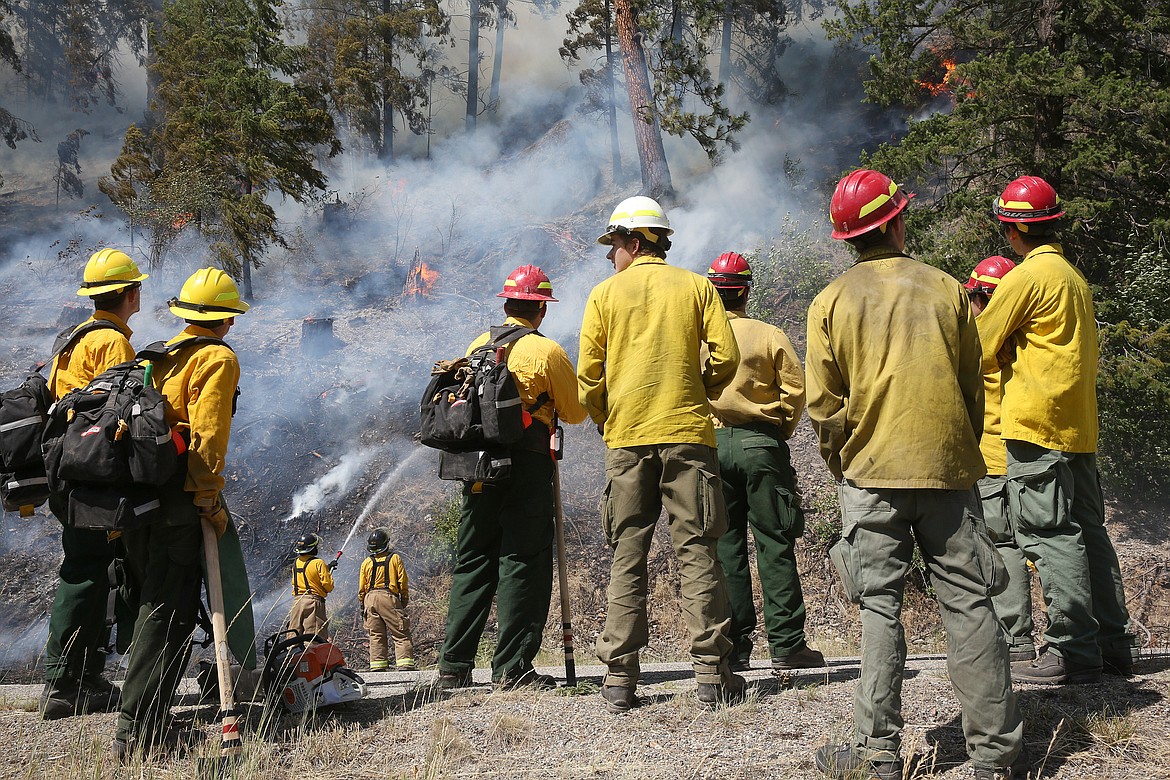 A U.S. Forest Service fire crew waits to attack a fire on the north side of Route 37 near the 4 mile marker Thursday afternoon. (John Blodgett/The Western News)