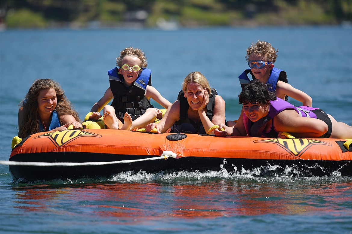 From left, volunteer Julia Houston, Easton Wheeler, volunteer Kathy Short, Meda Miles and Davin Wheeler enjoy a ride around Echo Lake during DREAM Adaptive Recreation's Summer Water Sports Program on Thursday. (Casey Kreider/Daily Inter Lake)