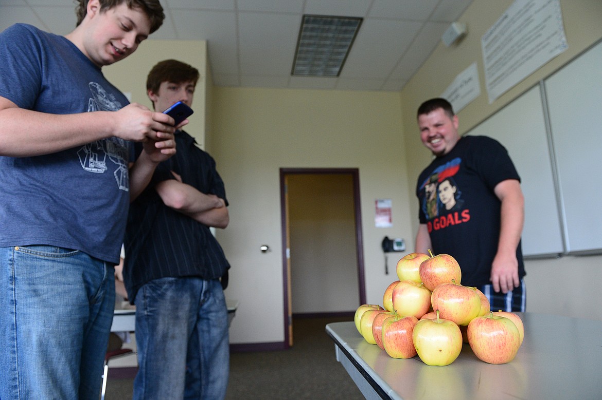 Students Ryan Stipe, Isaac Gilace and Levi Clatterbuck gather around a pile of apples left for instructor and Hollywood actress Kate Bosworth before the start of class at The Montana Academy of the Arts at Flathead Valley Community College on Wednesday. (Casey Kreider/Daily Inter Lake)