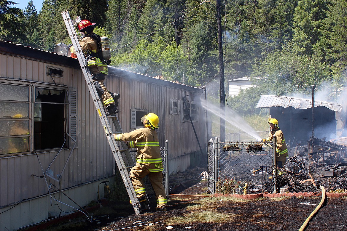 Firefighters with SCFD No.1 and Mullan Volunteer work to limit the damage to the trailer next to the one that initially caught fire.