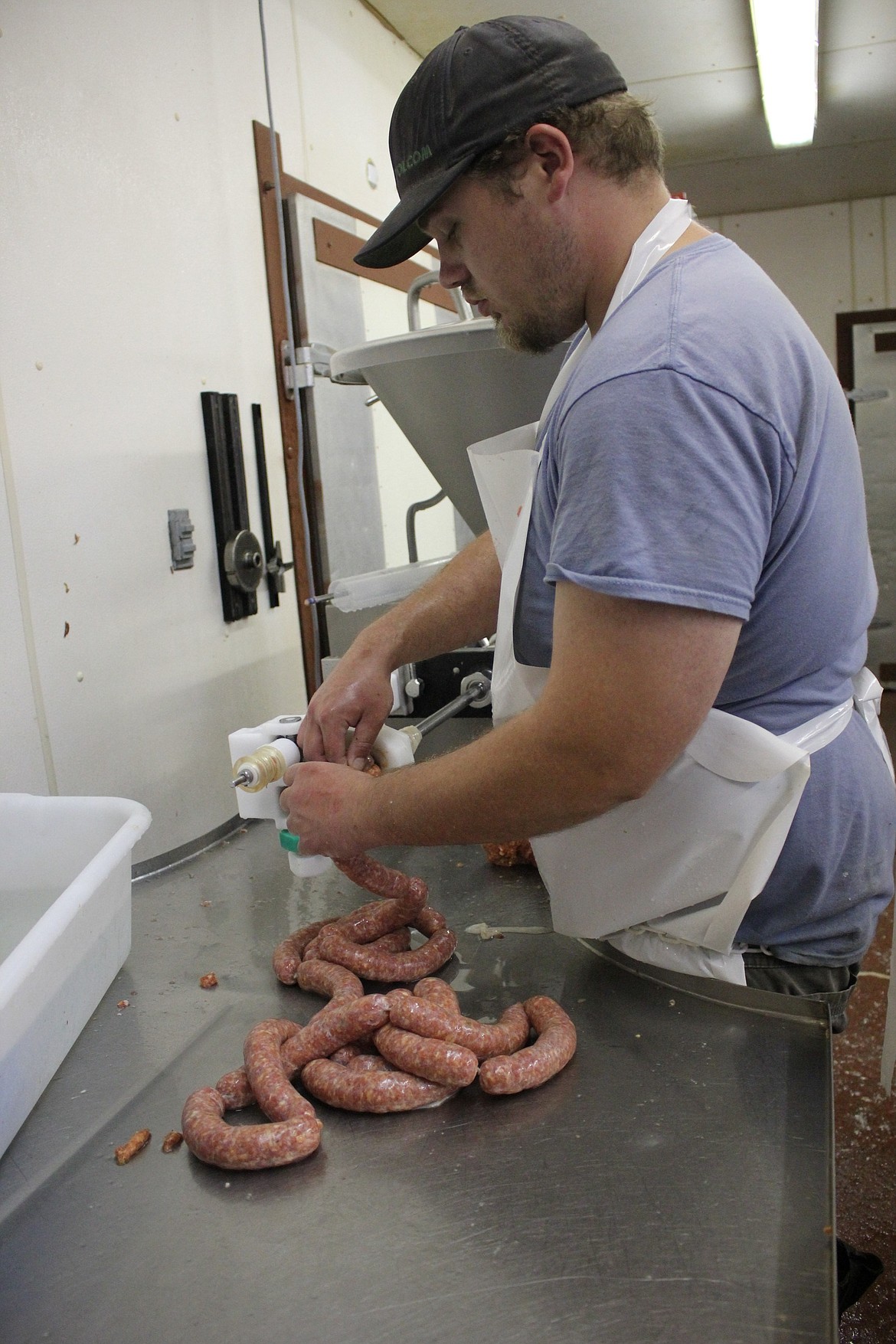 Superior Meats employee Josh Slavin fills sausage casing with a mixture from a recipe handed down to owner Jerry Stroot from his father.