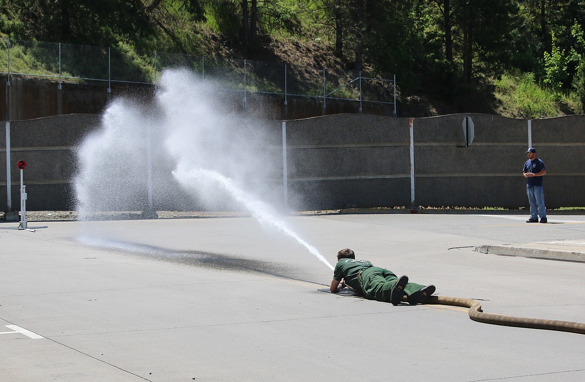 Right: The last firefighter in the line was in charge of knocking down the sign with the stream of water.