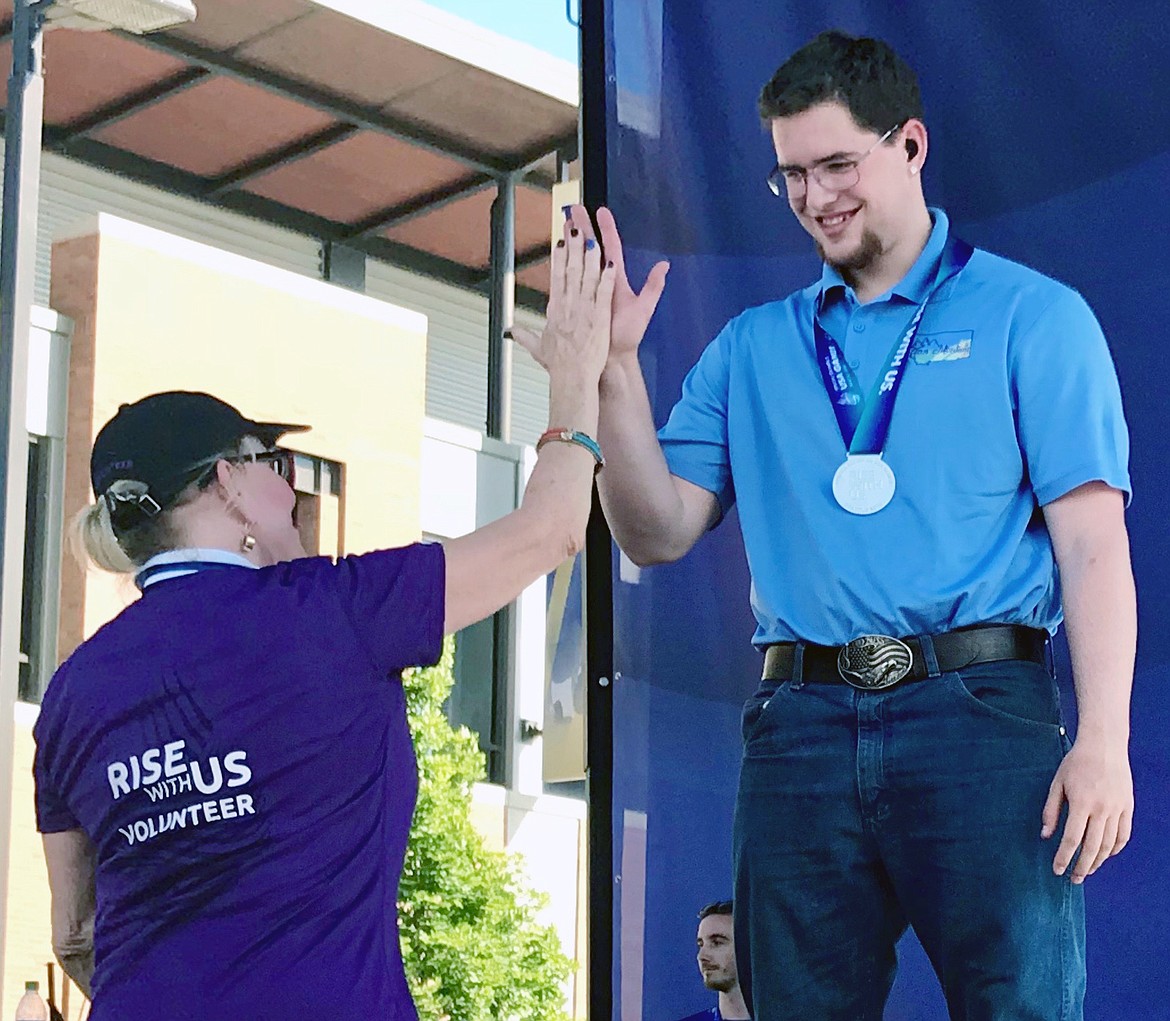 SPECIAL OLYMPIAN Chandler Krahn gets a high-five after receiving four silver medals in his age bracket. (Photo courtesy of Mike Krahn)