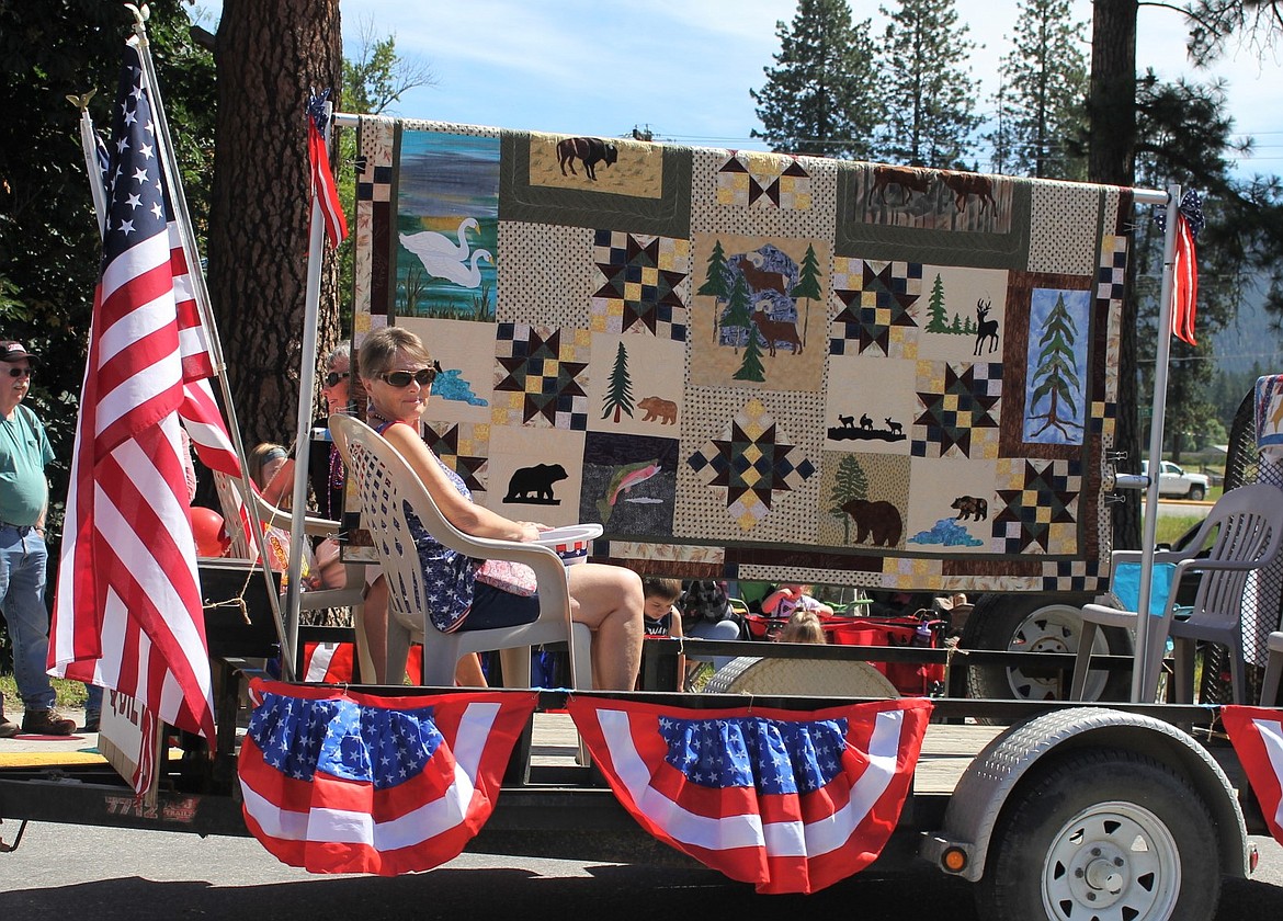 The Cabin Fever Quilters show off a quilt they are raffling off during the Independence Day parade in St. Regis.