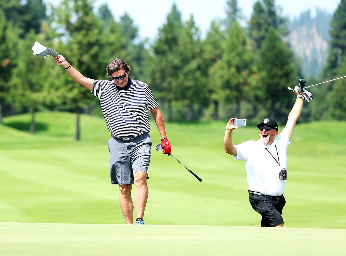 LOREN BENOIT/Press
Former NHL star Wayne Gretzky, aka &#147;The Great One,&#148; and a spectator react after Gretzky sank a 20-foot chip shot to finish the final nine holes with a 39 at The Showcase on Saturday at The Coeur d&#146;Alene Resort Golf Course.