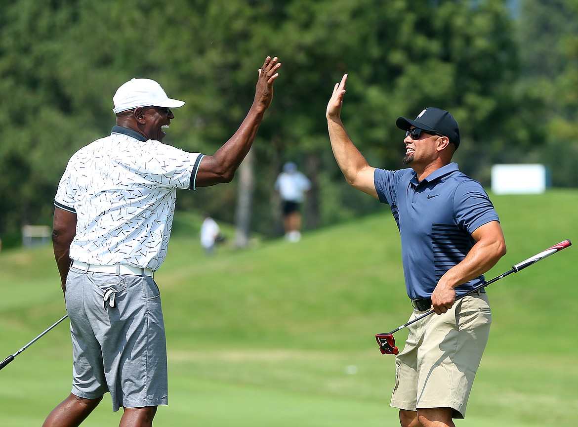 Four-time MLB Gold Glove winner and two-time All-Star Shane Victorino, right, high-fives six-time NFL Pro Bowler and Hall of Fame Inductee Eric Dickerson at the end of The Showcase on Saturday at The Coeur d&#146;Alene Resort Golf Course. (LOREN BENOIT/Press)