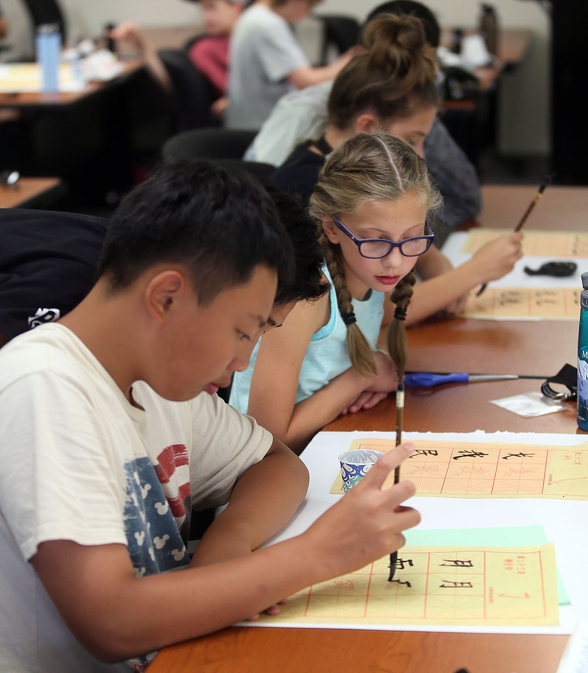 Freeman Middle School eighth-grader Lily Jones watches Jerry Zhang demonstrate proper calligraphy on Thursday. (JUDD WILSON/Press)