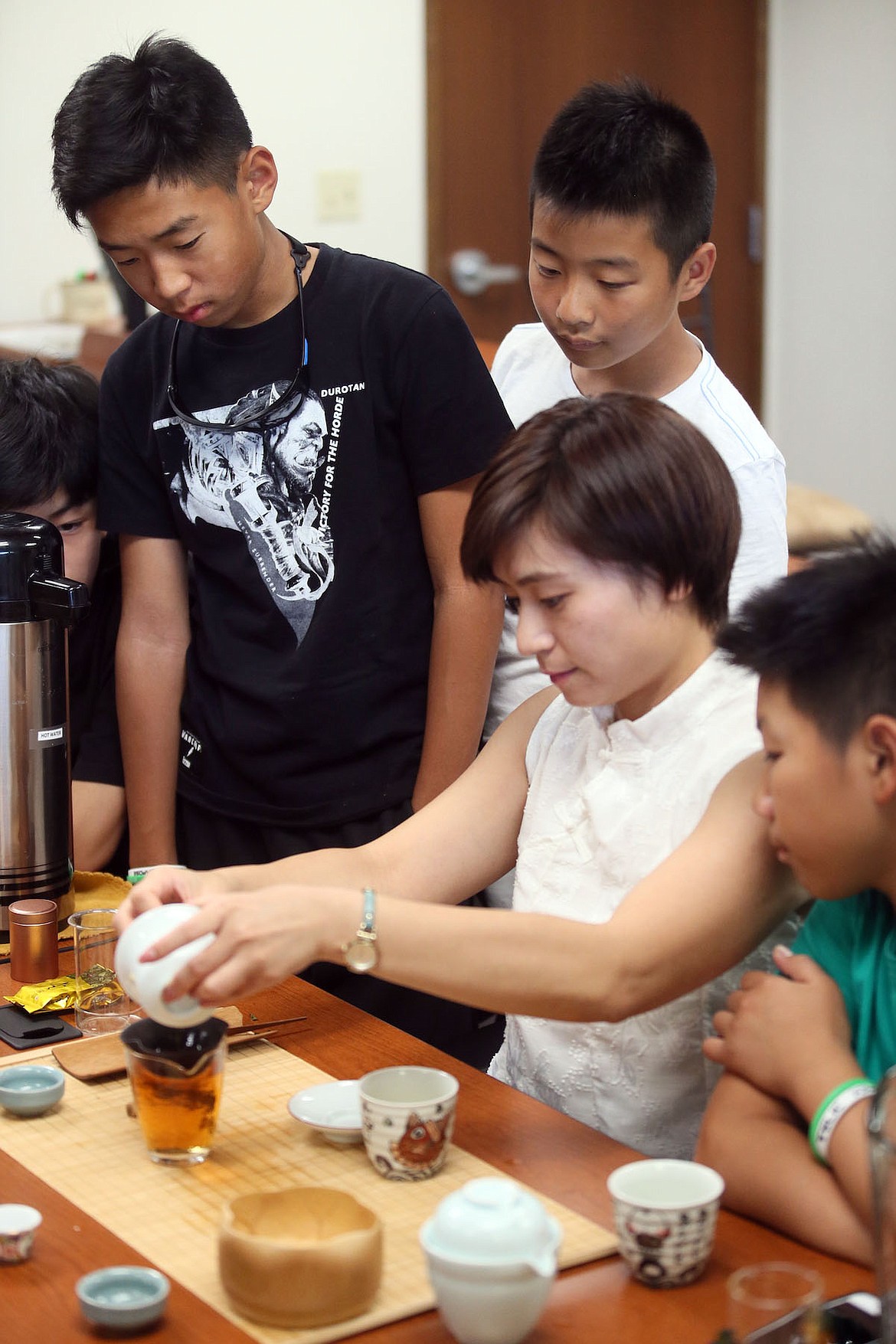 IDVenture founder Ying Xue pours tea while students from China prepare to serve their American friends during a traditional Chinese tea ceremony Thursday. (JUDD WILSON/Press)
