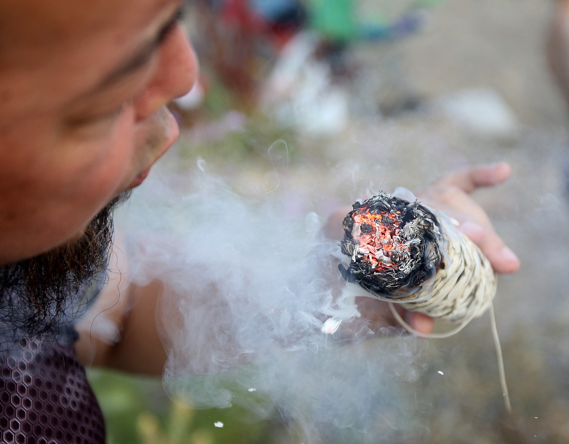 Judge Williams uses a sacred sage plant to clear and bless a space by the art of smudging Friday evening at SoulShine's Full Moon Gathering 2018 at Sanders Beach.(LOREN BENOIT/Press)