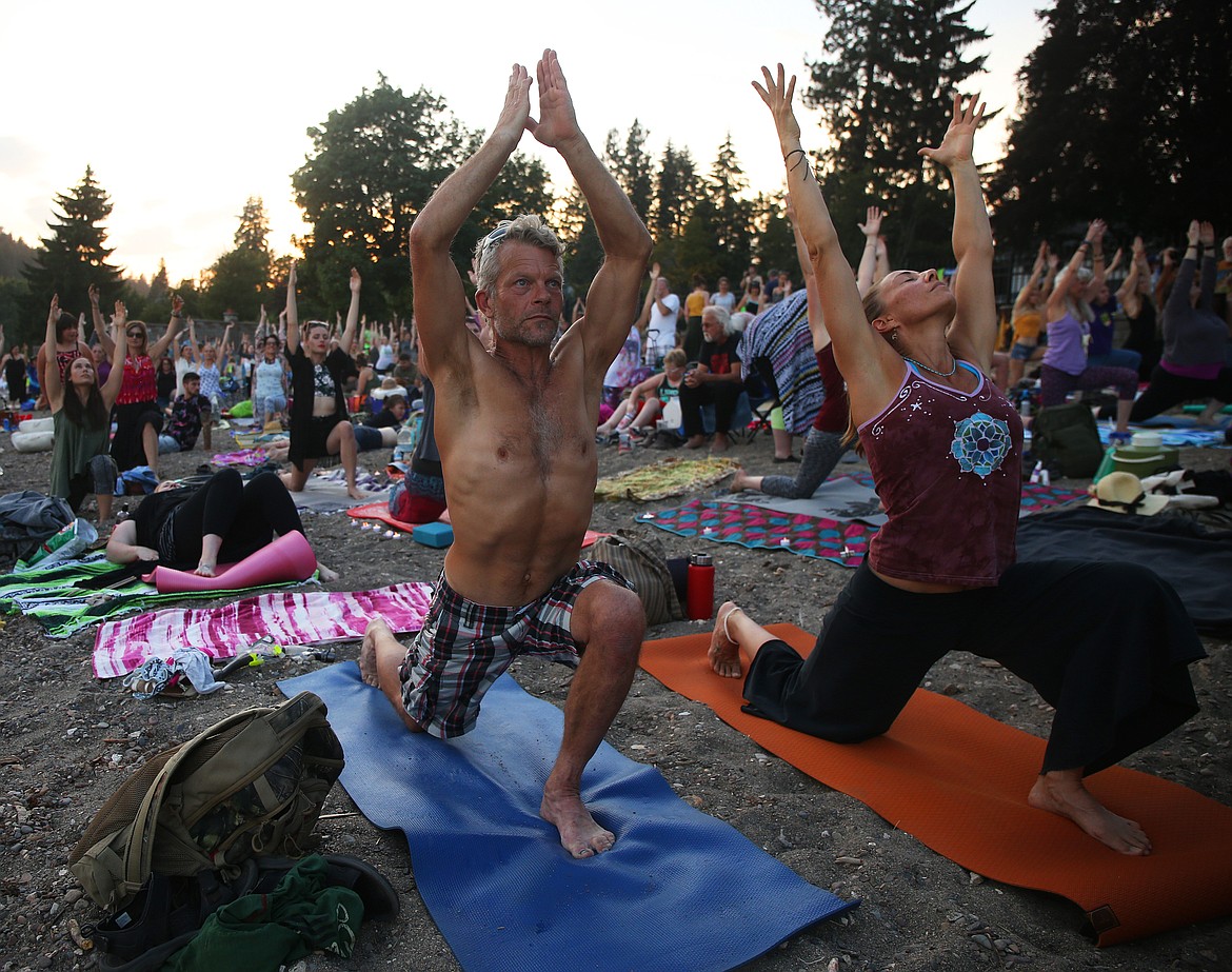 Ric Stordahl and Mary Ragsdale join in a group yoga exercise Friday evening at SoulShine&#146;s Full Moon Gathering 2018 at Sanders Beach.