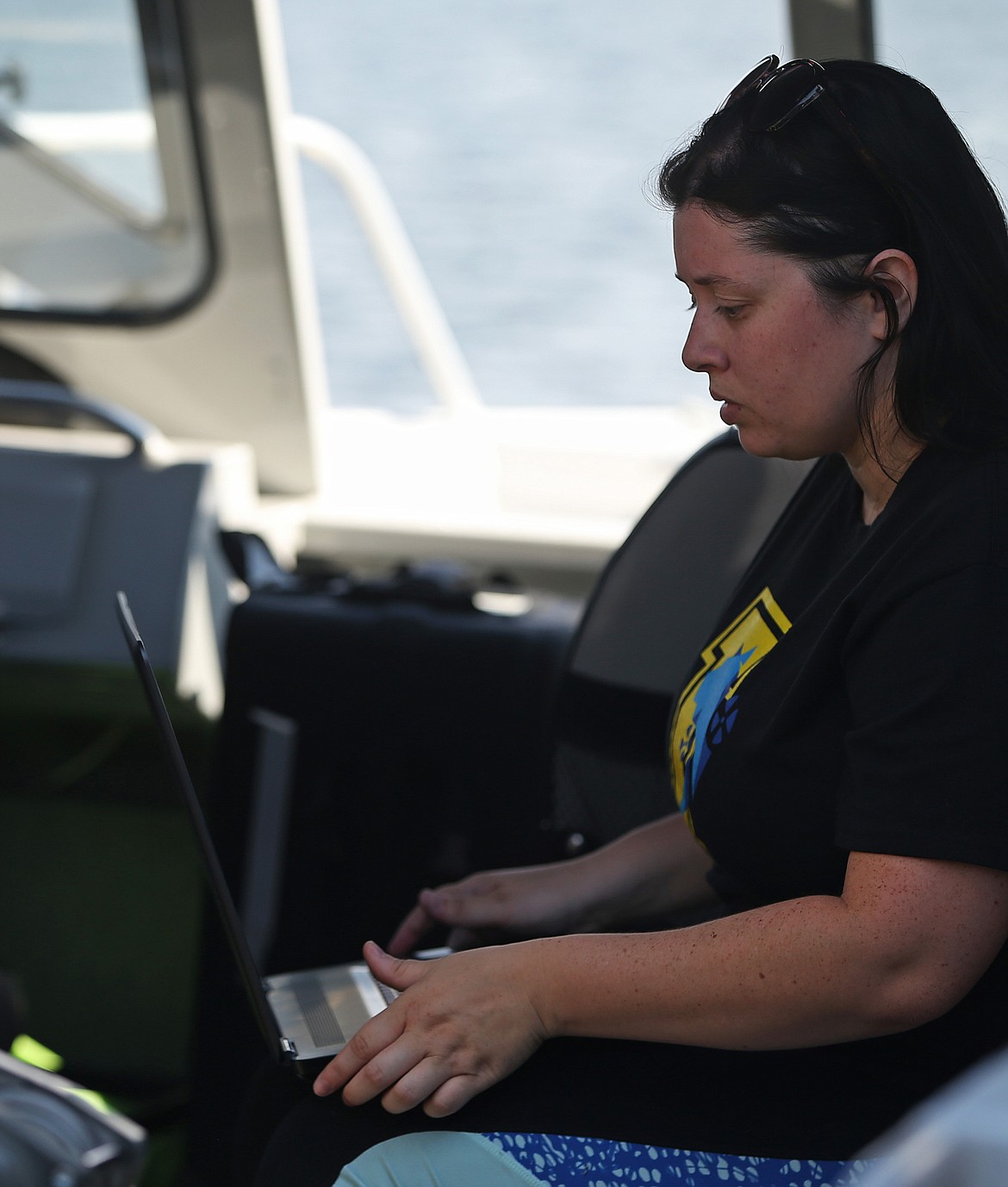 University of Idaho Coeur d'Alene undergraduate researcher Sam Freitas runs through her checklist on her laptop before lowering a  submersible drone into Lake Coeur d'Alene. Both Freitas and graduate researcher Adrian Beehner have spent more than 1,000 hours working to program artificial intelligence into the submersible drone &quot;Catfish.&quot;  (LOREN BENOIT/Press)